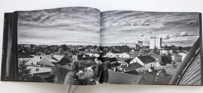 Blick über die Dächer der Nadelburg und Lichtenwörth in Schwarz-Weiß mit Wolken im Hintergrund.