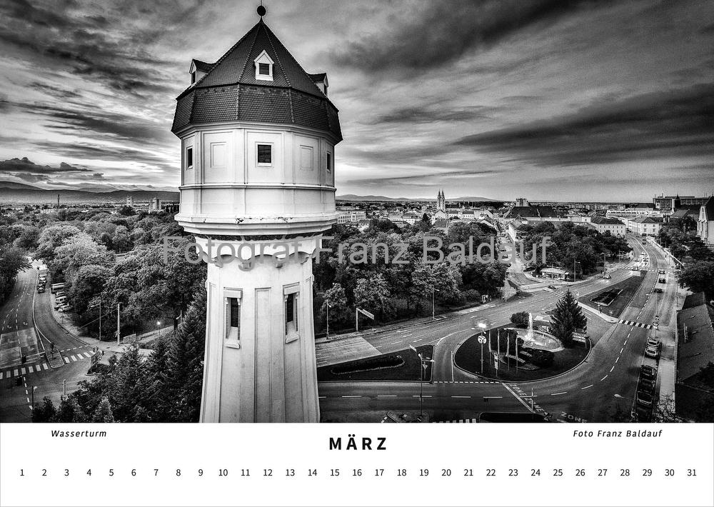 "WIENER NEUSTADT" fotografiert von Franz Baldauf 8 Schwarz-weiß Fotografie des Wasserturms in Wiener Neustadt im März, mit Blick über die Stadt und dramatischen Wolken am Himmel, die architektonische Schönheit und das Stadtbild betonen.