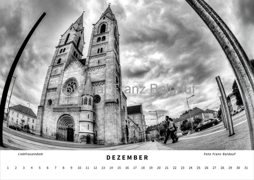 "WIENER NEUSTADT" fotografiert von Franz Baldauf 16 Schwarz-weiß Fotografie des Liebfrauendoms am Domplatz in Wiener Neustadt im Dezember, die die majestätische Fassade der Kirche und Passanten in einer lebendigen städtischen Atmosphäre zeigt.